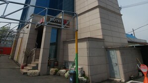 A hotel with a modern design, featuring a prominent glass facade and a traditional brick section.