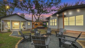 A modern house with a patio area featuring outdoor seating and a fire pit. - Bubbles on Bowie Walk to Main St (Fredericksburg)