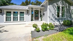 A two-story house with a front porch, a garage, and a well-maintained lawn.