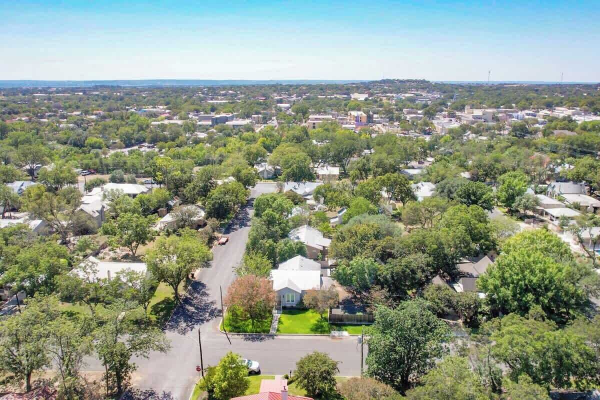Vue aérienne d’un quartier résidentiel avec des maisons, des routes et de la végétation.