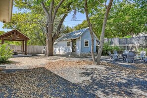 A small house with a porch, a fenced yard, and outdoor furniture. - Modern Luxurious Home With Game Room (Fredericksburg)