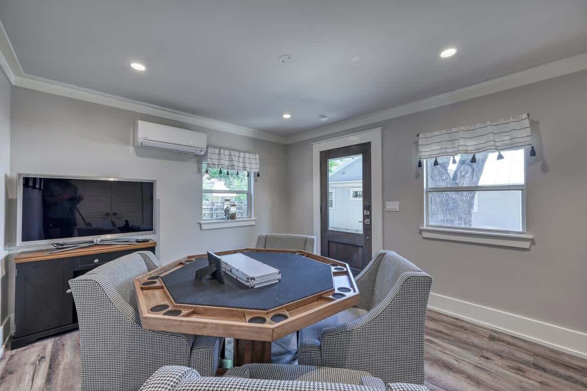A spacious living room with a large TV, a round table, and two sofas.