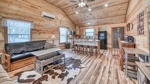 L'intérieur d'une cabine est doté d'un plafond en bois, d'un canapé en cuir noir, d'une table à manger et d'un coin cuisine.