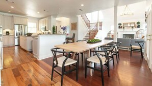 Une cuisine spacieuse dotée d’un grand îlot central, de planchers en bois et d’appareils électroménagers modernes.