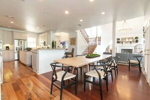 Una cocina amplia con una isla grande, piso de madera y electrodomésticos modernos.