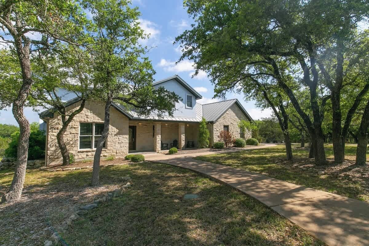 Ein zweistöckiges Haus mit einer Stein-Fassade und einer Veranda.