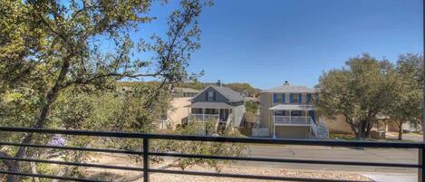 A residential area with houses, a clear sky, and a fence in the foreground.