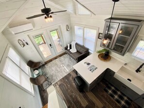 A modern kitchen with a central island, a dining area with a patterned rug, and a ceiling fan. - Resort at Fredericksburg Unit 1 (Fredericksburg)