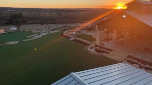 A golf course with a clubhouse and a sunset in the background. - Resort at Fredericksburg Unit 1 (Fredericksburg)