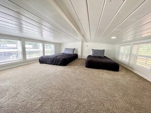 A room with two beds, large windows, and a high ceiling. - Resort at Fredericksburg Unit 1 (Fredericksburg)