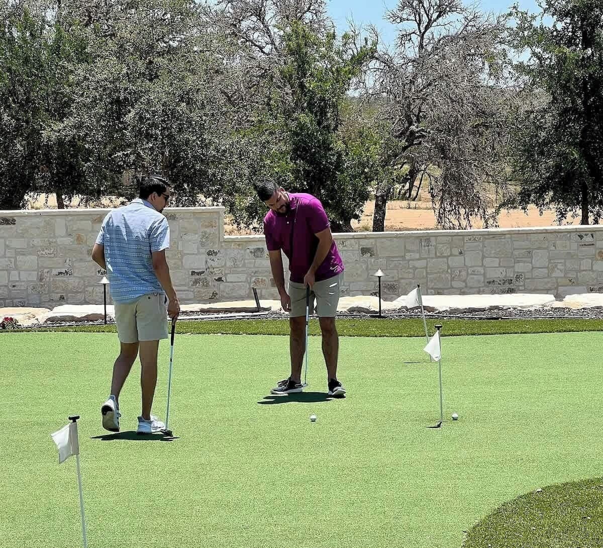 A golf course with two players preparing to take a shot.