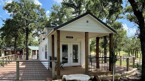 A white building with a porch and a sign that reads "ZION". - Resort at Fredericksburg Unit 1 (Fredericksburg)