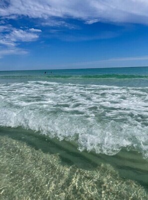 Une plage avec une eau claire et des vagues.
