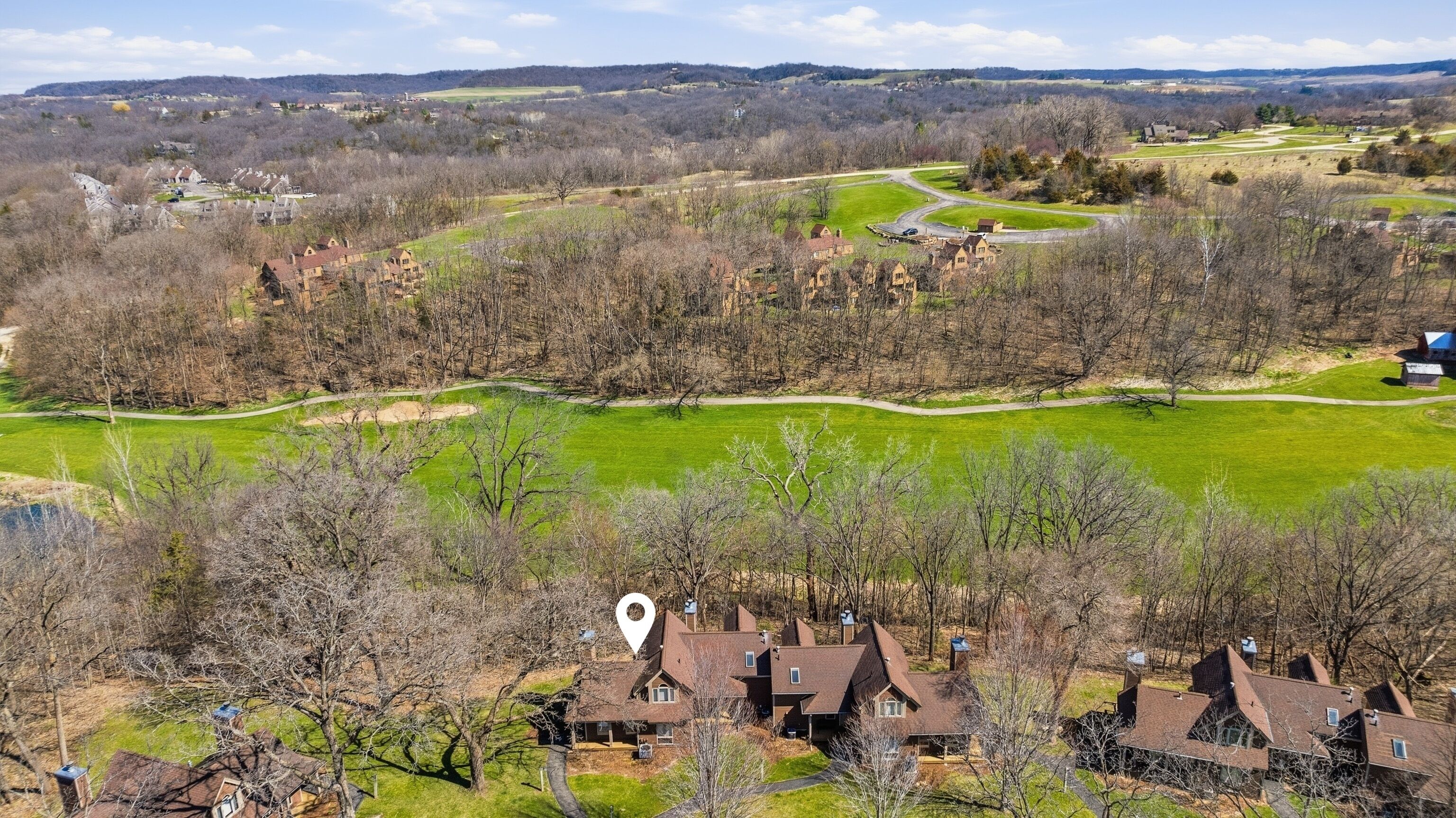 A residential area with houses, a golf course, and a large open field.
