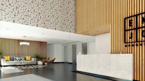 A modern lobby with a reception desk, a seating area with a sofa and chairs, and a patterned wall. - Unique Apartment. 5 Guests. 3 Bedrooms. 2 Baths. (Lima)