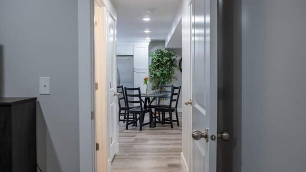A hallway leading to a dining area with a table and chairs. - Spacious Basement Apartment (Eagle Mountain)