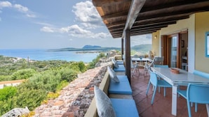A terrace with a view of the sea, outdoor seating, and a wooden pergola. - Porto Rotondo Vista Incantevole sul Mare e Yacht (Olbia)