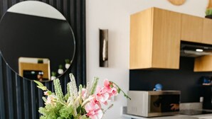 Uma cozinha moderna com armários de madeira, um espelho redondo e uma planta decorativa.