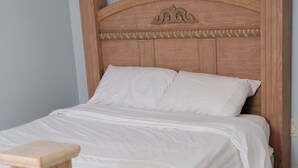A wooden bed with a headboard, white bedding, and a wooden nightstand. - Cozy Basement Apt two bedrooms sleep 4
You can enjoy TEA & COFFEE with no charge (Barrie)