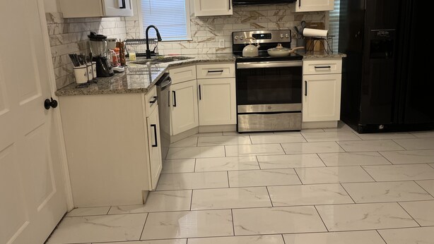 A modern kitchen with white cabinets, a stainless steel oven, a black refrigerator, and a microwave. - House of Treasure, a stylish property located 8 minute from Downtown Dallas. (Dallas)