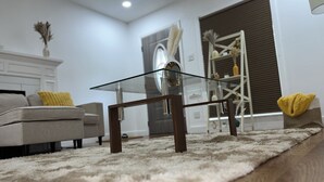 A modern living room with a glass coffee table, a sofa, and a fluffy rug. - House of Treasure, a stylish property located 8 minute from Downtown Dallas. (Dallas)