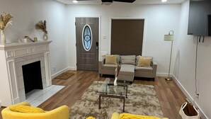 A modern living room with a fireplace, a sofa set, a coffee table, and a television. - House of Treasure, a stylish property located 8 minute from Downtown Dallas. (Dallas)