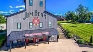 Un bâtiment sur lequel on peut lire l’inscription « Jim Beam », et en dessous, une plus petite inscription indiquant « Distillerie américaine ».