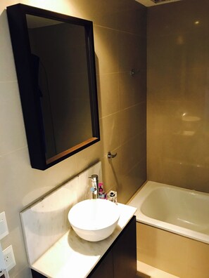 A bathroom with a white sink, a mirror, and a bathtub. - PB by medrano SUITS (Buenos Aires)