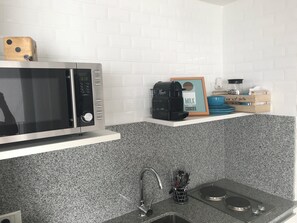 A kitchen with a microwave, coffee maker, and a framed sign that says "MILK AND COOKIES". - PB by medrano SUITS (Buenos Aires)