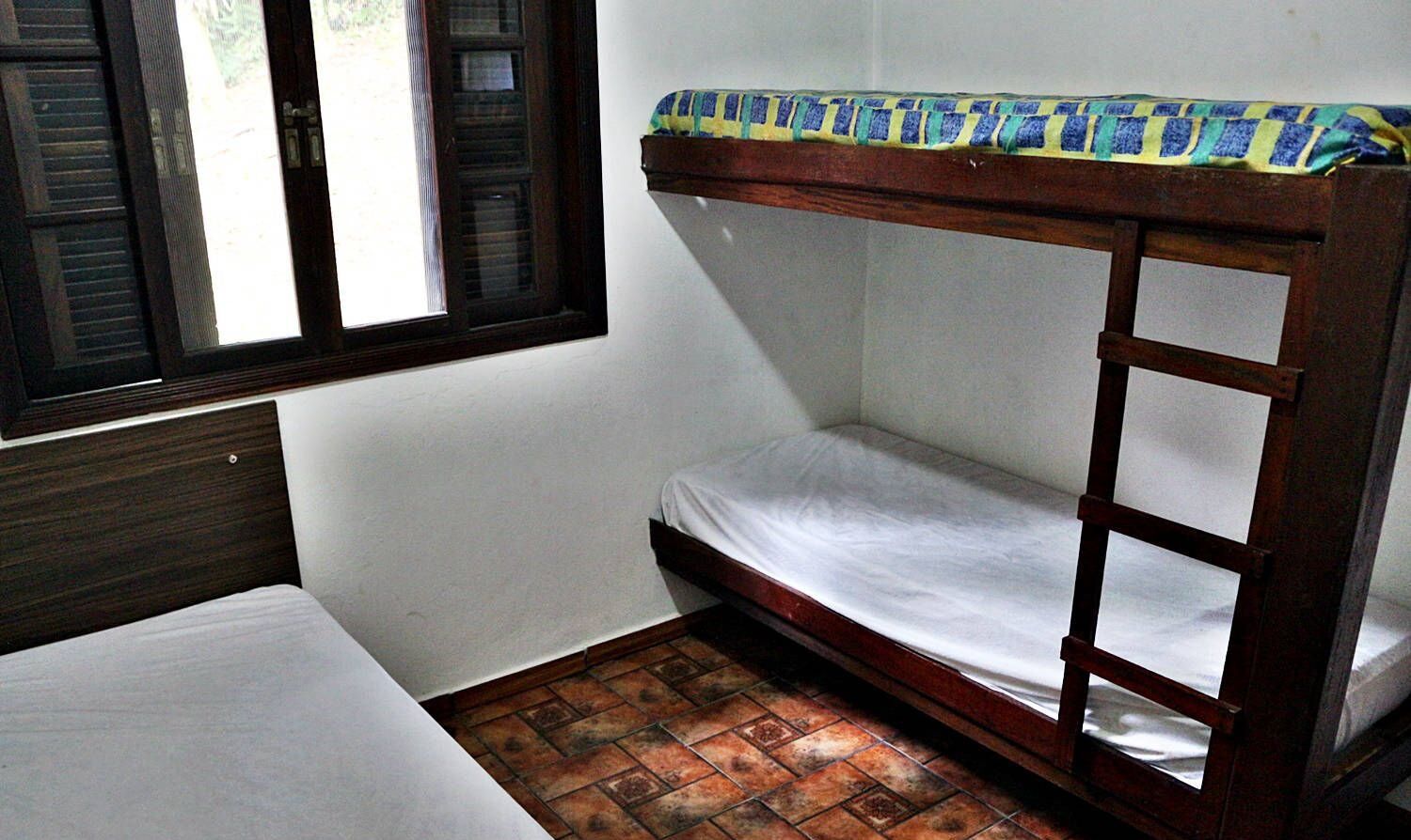 Un piccolo alloggio in un'unica stanza con un letto a castello e un letto singolo.