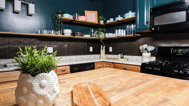 A kitchen with wooden countertops, a central island, and a microwave.