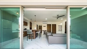 Een modern interieur met een eethoek, een bank en een plafondventilator.