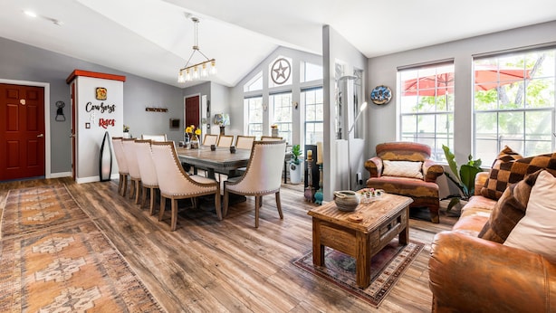 A spacious living room with a dining area, large windows, and a cozy seating area. - Cowboys & Roses - Wine Country Home w/Game Room, Hot Tub & Views - Dogs Welcome! (Cornville)