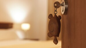 A keychain with a turtle-shaped keychain holder attached to a door handle.