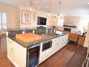 Enjoy cooking in the well-equipped kitchen with a large island, gas range, and ample counter space.