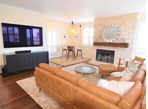 Relax in this stylish living room with a flat-screen TV, comfortable sofa, and cozy fireplace.
