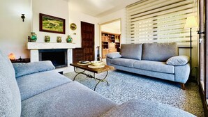 A living room with a fireplace, a sofa, a coffee table, and a lamp.