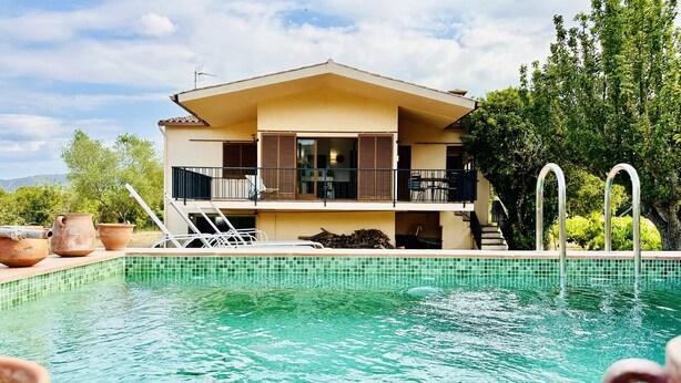 A two-story building with a swimming pool in front.
