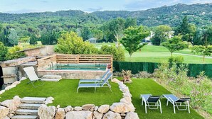 A backyard with a swimming pool, stone steps, and lounge chairs.
