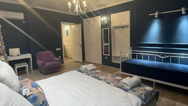 Une chambre à coucher avec un grand lit, une chaise, un bureau et une armoire.