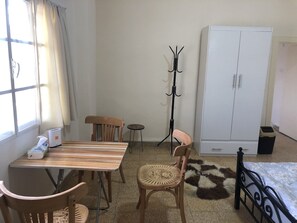 Cozy retreat with a wooden dining table, comfortable chair, and a stylish wardrobe.