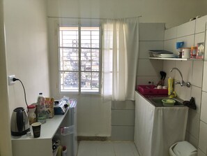 Enjoy a city view from the kitchen window, where you can find a kettle, sink, and countertop with essentials.