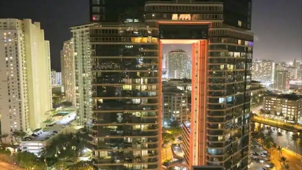 Un edificio a grattacielo con numerosi piani, caratterizzato da uno spazio aperto centrale con una struttura rossa.