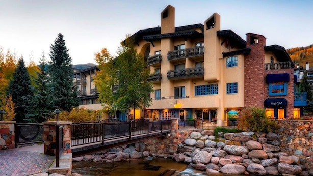 A multi-story hotel with balconies, a stone pathway, and a small water feature.