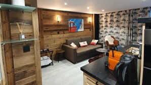 A modern kitchen with wooden cabinetry, a black countertop, and a coffee machine. - Studio Moderne Spacieux Avec VUE Imprenable ! (Tignes)