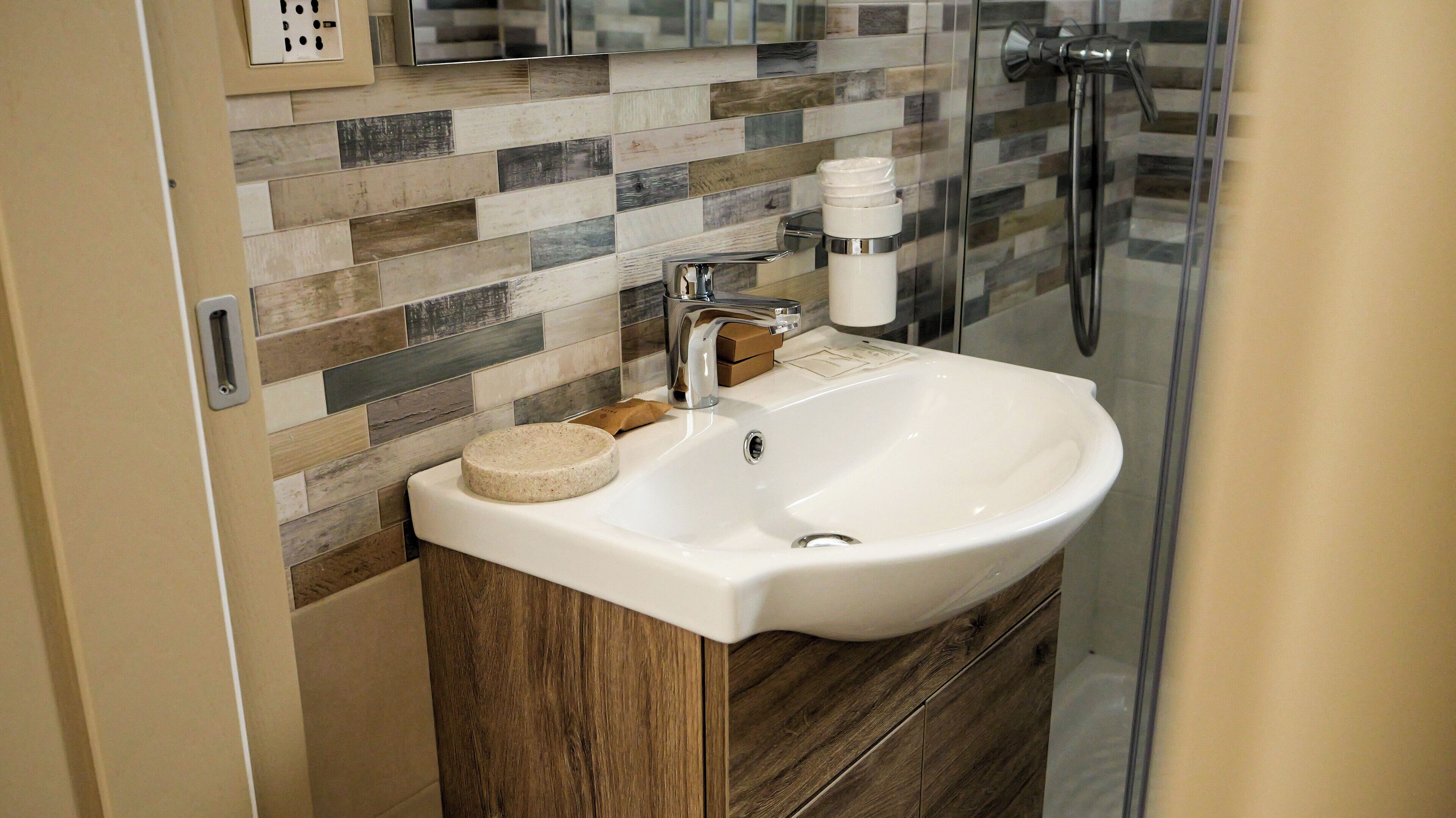 A bathroom with a white sink, a mirror, and a shower.
