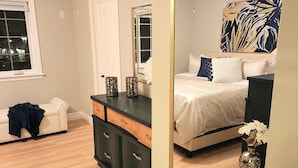 A bedroom with a large mirror, a bed with white bedding, a dresser with drawers, and a window with blinds. - *WOW!* Executive Cozy Home - 3 bedroom, 2 bath (Paradise)