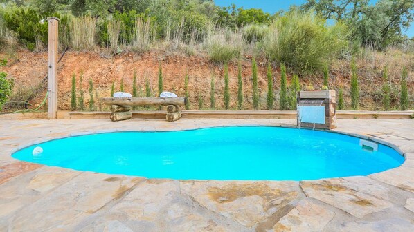 Ein Schwimmbecken mit Holzterrasse und einer Holzbank.