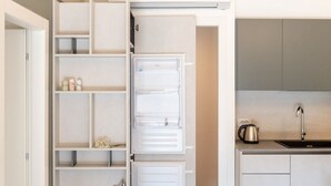 A compact kitchen with a built-in refrigerator, a kettle, and a sink. - Cozy and uniquely designed apartment (Riva di Solto)