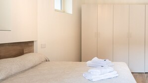 A hotel room with a bed, a wardrobe, and a window. - Cozy and uniquely designed apartment (Riva di Solto)